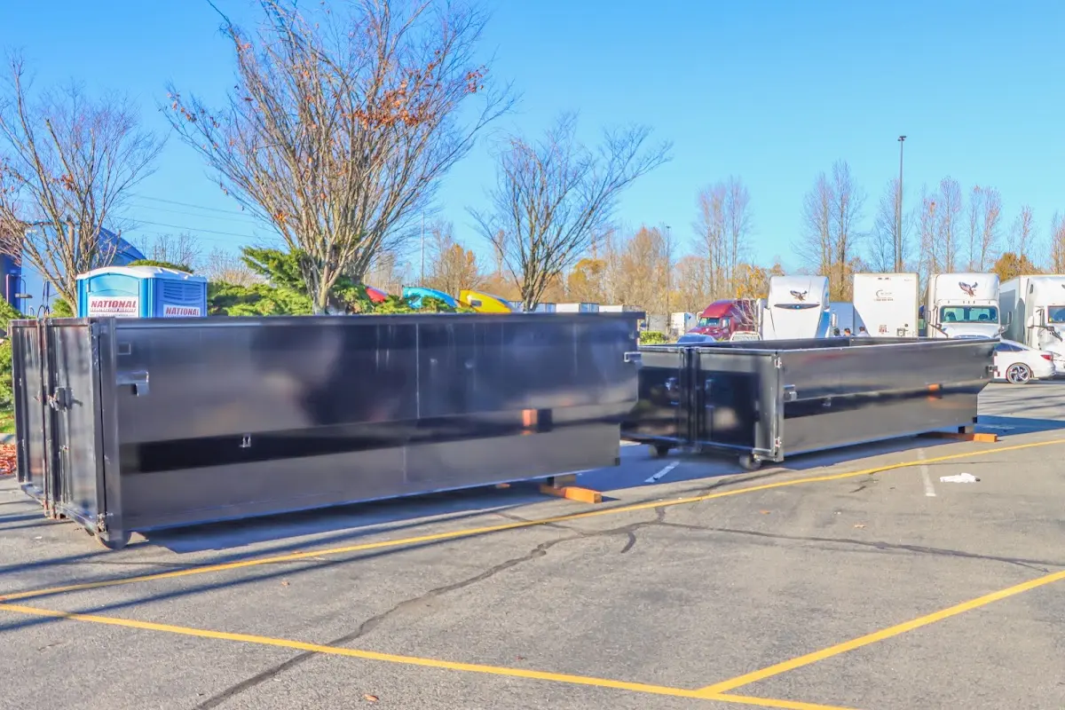 Professional dumpster rental service with roll-off container on residential driveway in Muskegon